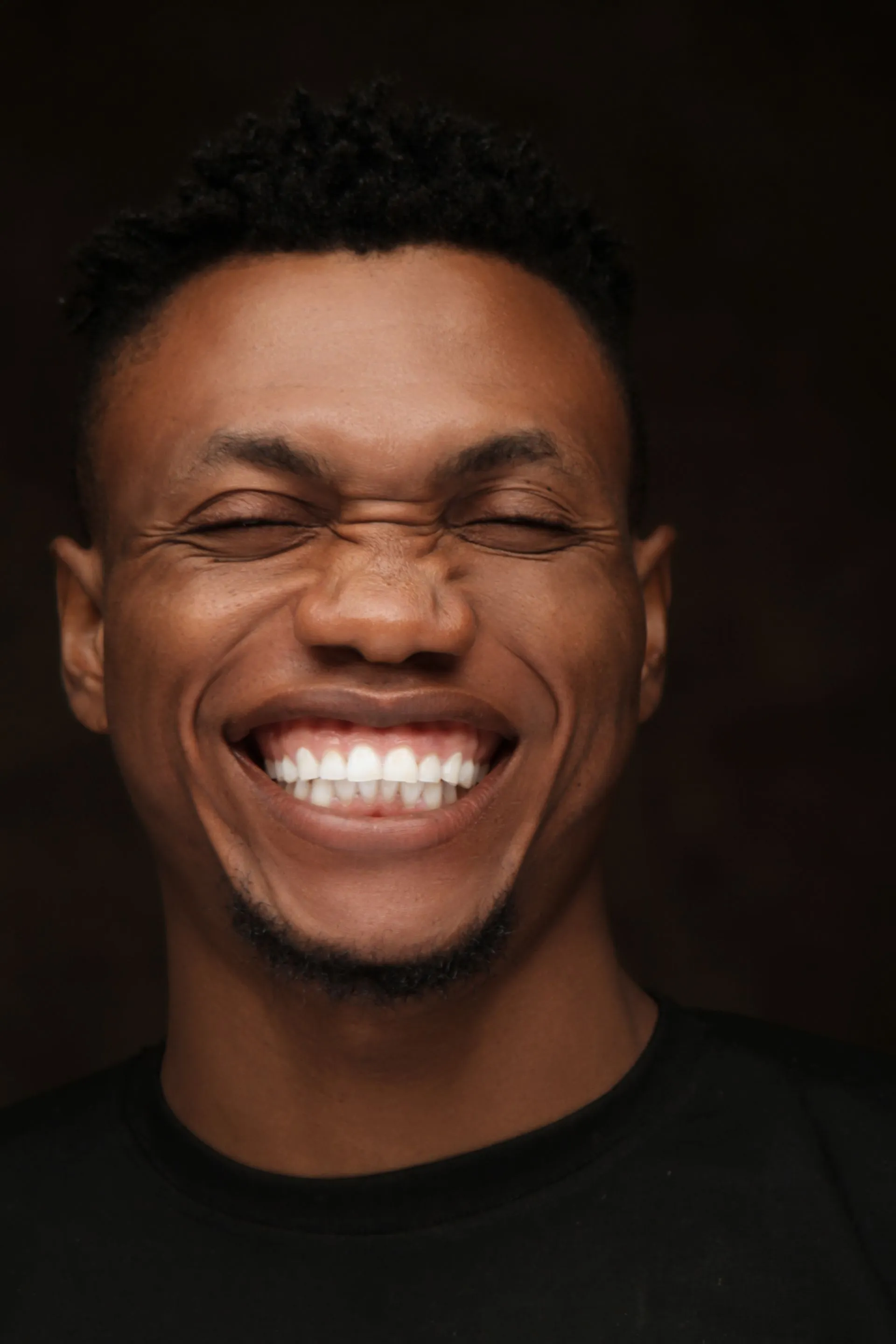 Hombre sonriendo abiertamente mostrando una dentadura cuidada